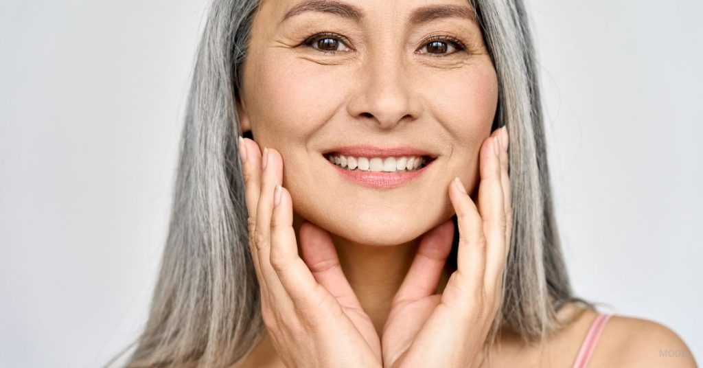 mature woman holding her face admiring her skim (MODEL)